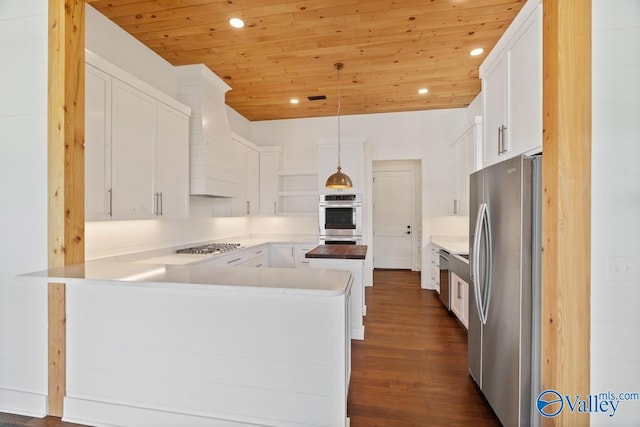 kitchen featuring white cabinetry, hanging light fixtures, dark hardwood / wood-style flooring, kitchen peninsula, and appliances with stainless steel finishes