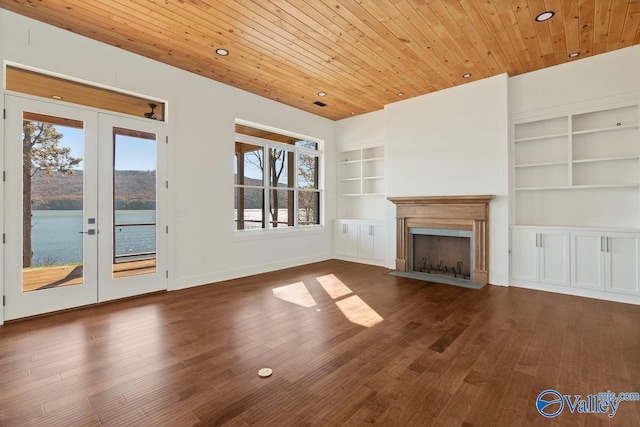 unfurnished living room featuring a wealth of natural light, french doors, a water view, and dark hardwood / wood-style floors