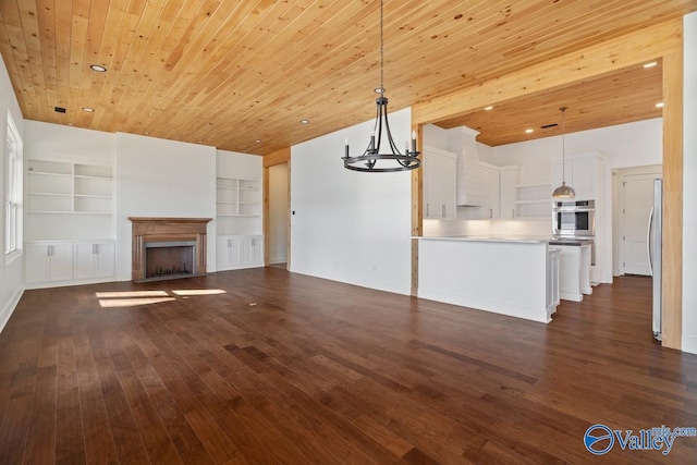 unfurnished living room featuring built in shelves, a chandelier, dark hardwood / wood-style flooring, and wood ceiling