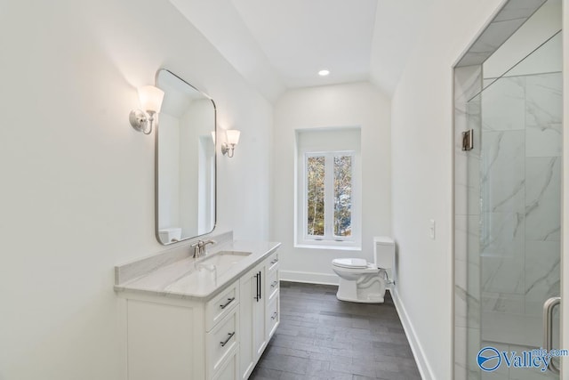 bathroom featuring vanity, hardwood / wood-style floors, lofted ceiling, toilet, and a shower with shower door