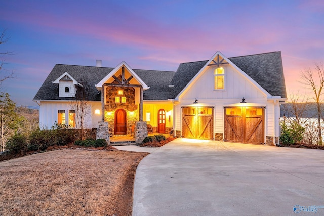 modern farmhouse with board and batten siding, concrete driveway, a shingled roof, and a garage