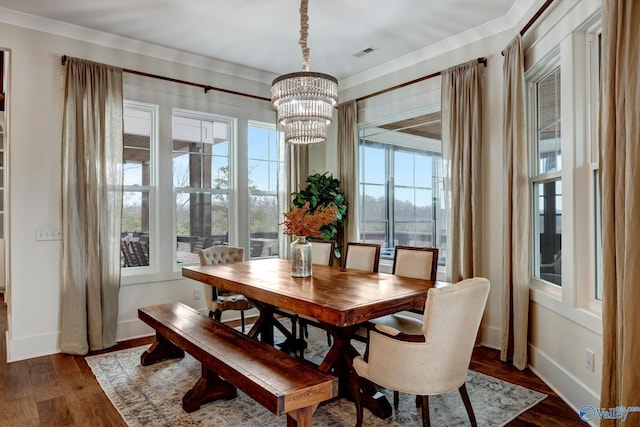 dining room with dark wood-style floors, ornamental molding, visible vents, and baseboards