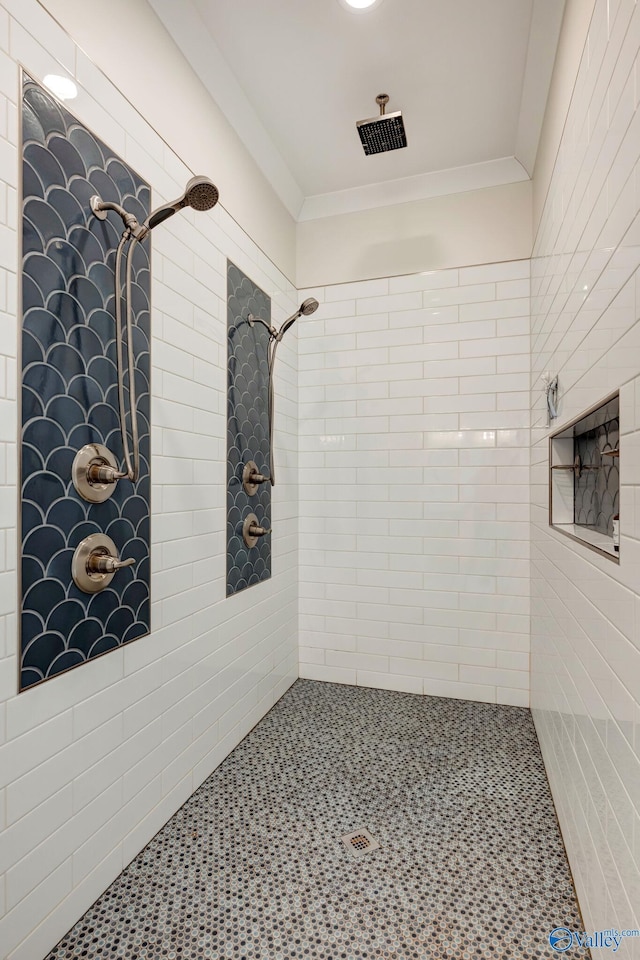 bathroom featuring a tile shower and crown molding