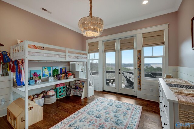 bedroom with dark wood-type flooring, a chandelier, and ornamental molding