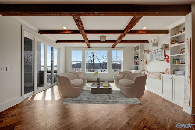 living room with beamed ceiling, wood-type flooring, built in shelves, and coffered ceiling