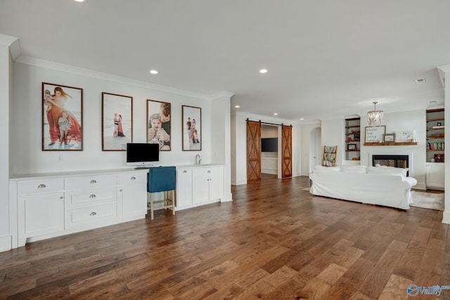 unfurnished living room featuring dark wood-style flooring, recessed lighting, visible vents, a barn door, and ornamental molding