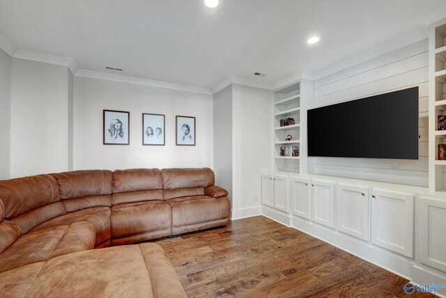 living room featuring hardwood / wood-style flooring, built in shelves, and ornamental molding