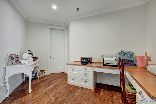 office with crown molding, hardwood / wood-style flooring, and built in desk