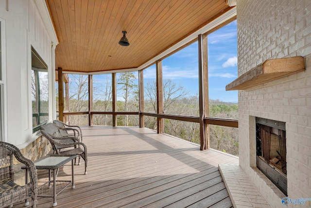sunroom featuring wood ceiling and an outdoor brick fireplace
