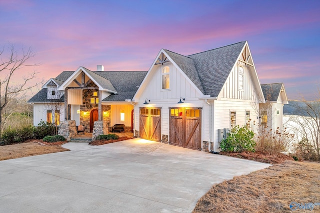modern farmhouse style home featuring board and batten siding, concrete driveway, roof with shingles, and a chimney