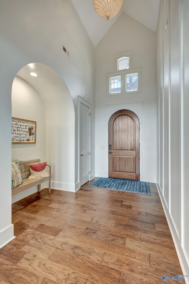 foyer with light hardwood / wood-style floors and high vaulted ceiling