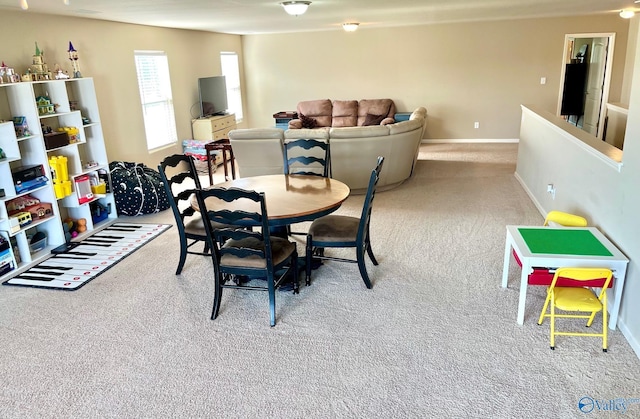 dining space featuring baseboards and light colored carpet