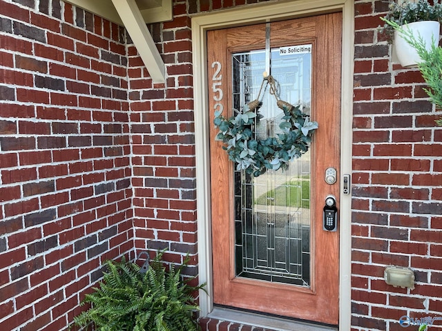 doorway to property with brick siding