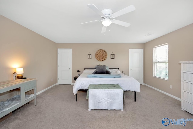 bedroom featuring a ceiling fan, light carpet, and baseboards