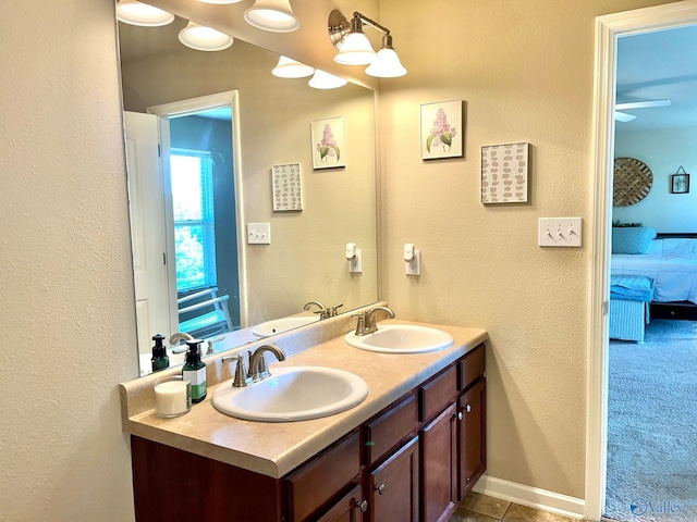 ensuite bathroom with a sink, double vanity, and connected bathroom