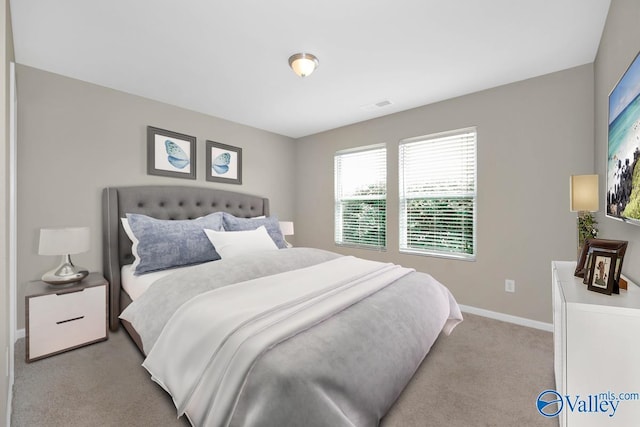 bedroom with light carpet, visible vents, and baseboards