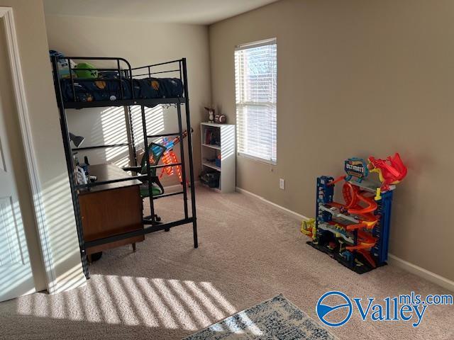 bedroom featuring light colored carpet and baseboards