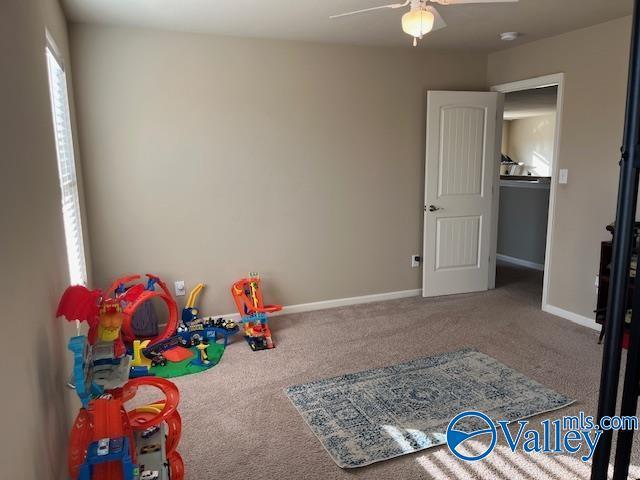 recreation room featuring carpet floors, baseboards, and a ceiling fan