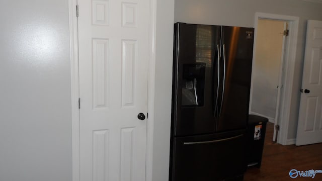 room details featuring black fridge and dark wood-type flooring