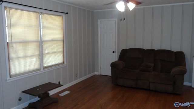 living area featuring ceiling fan, dark hardwood / wood-style flooring, and ornamental molding