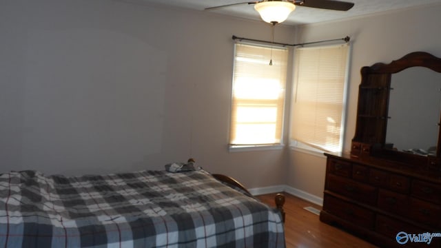 bedroom featuring hardwood / wood-style floors, ceiling fan, and ornamental molding