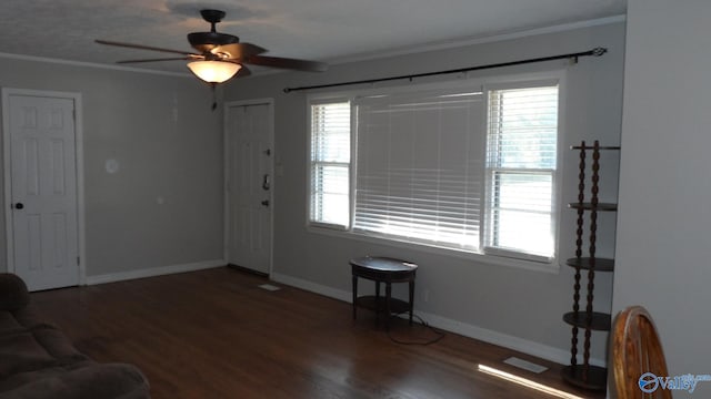 entrance foyer featuring ceiling fan, plenty of natural light, dark hardwood / wood-style floors, and ornamental molding