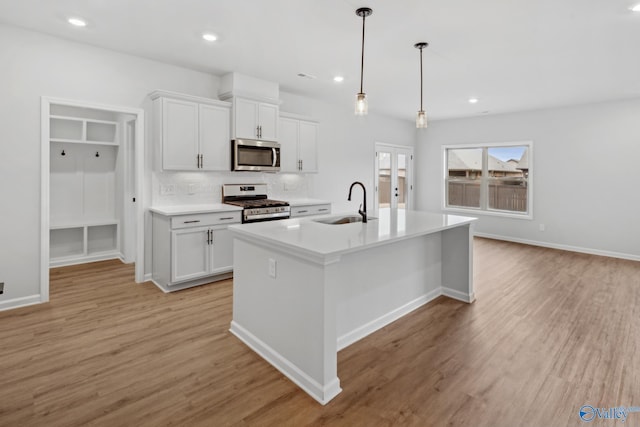 kitchen featuring white cabinetry, appliances with stainless steel finishes, sink, and a center island with sink