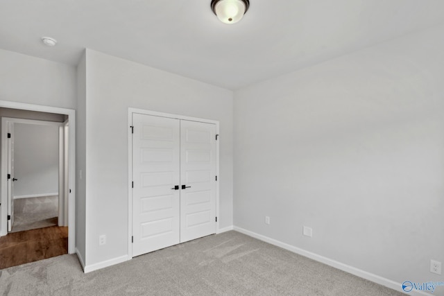 unfurnished bedroom with light carpet and a closet