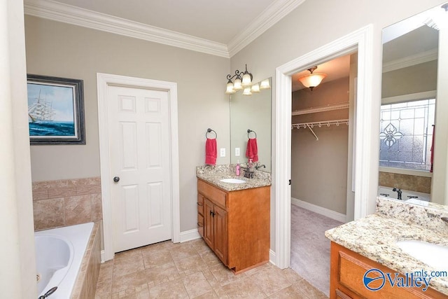 bathroom with vanity, tile patterned floors, crown molding, and tiled tub