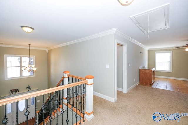 hall with light carpet, crown molding, and a notable chandelier