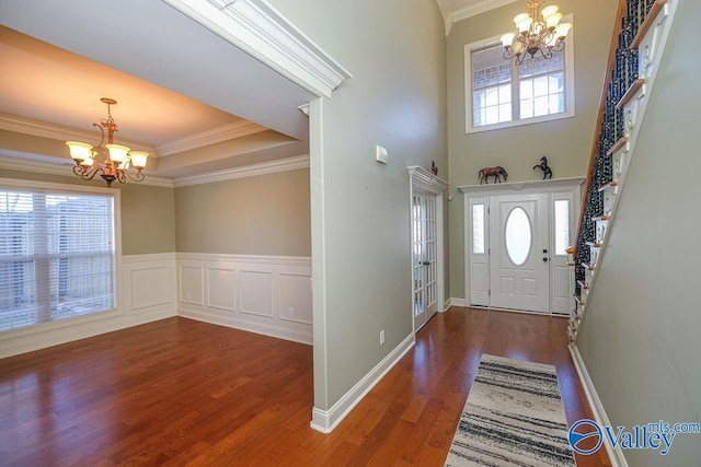 foyer with a chandelier, ornamental molding, and plenty of natural light