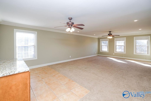 empty room with ceiling fan, light colored carpet, and ornamental molding