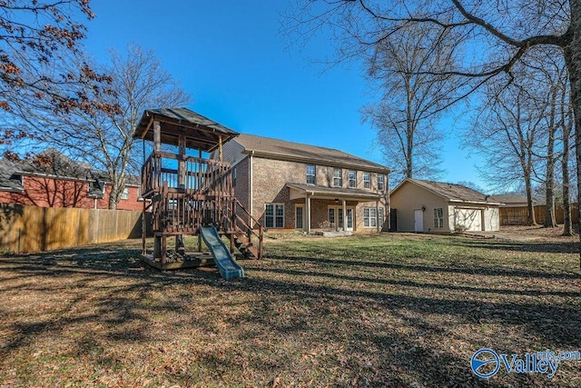 rear view of house featuring a playground, an outbuilding, and a lawn