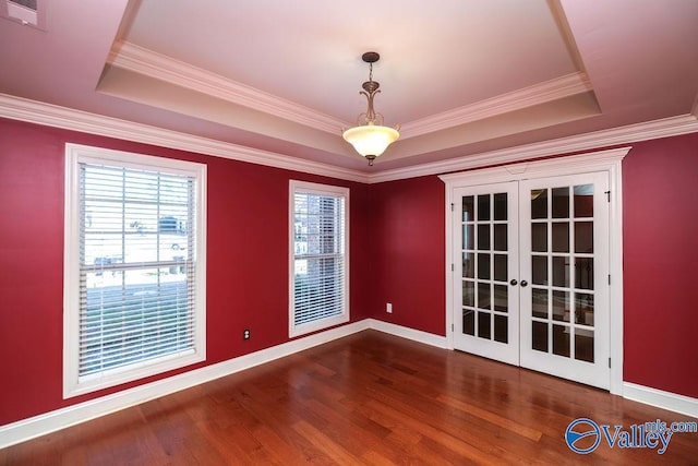 unfurnished room with french doors, dark hardwood / wood-style flooring, a tray ceiling, and ornamental molding