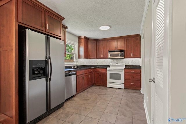 11021 Jean Rd SE, Huntsville, AL 35803 - kitchen featuring light tile patterned flooring, dark countertops, stainless steel appliances, and a sink