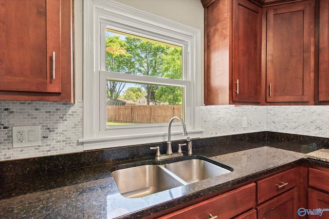 11021 Jean Rd SE, Huntsville, AL 35803 - kitchen featuring dark stone countertops, a sink, and backsplash