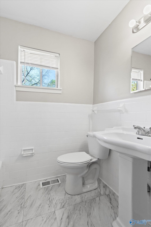 11021 Jean Rd SE, Huntsville, AL 35803 - bathroom featuring tile walls, marble finish floor, a wealth of natural light, toilet, and visible vents