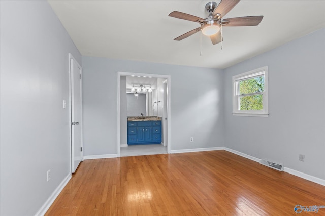 11021 Jean Rd SE, Huntsville, AL 35803 - unfurnished living room featuring visible vents, a ceiling fan, a sink, baseboards, and light wood-style flooring