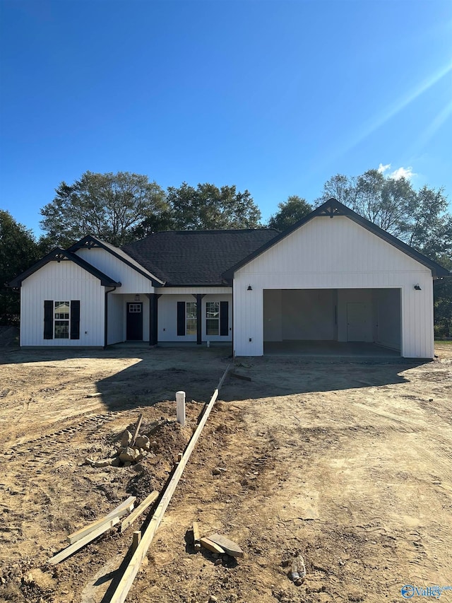 ranch-style house featuring a garage, driveway, and a shingled roof