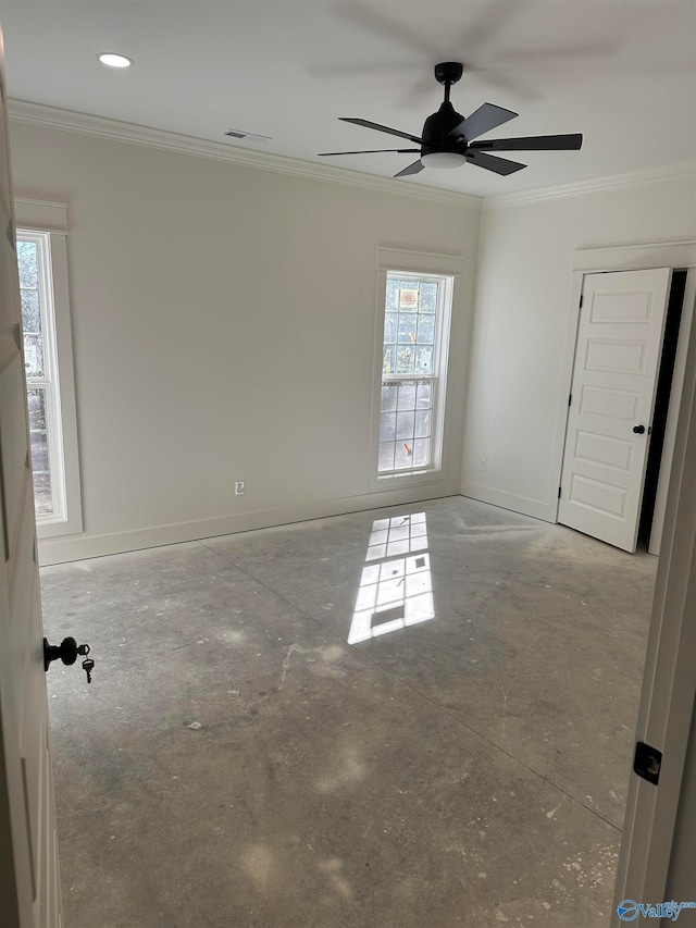 empty room with a ceiling fan, visible vents, crown molding, and baseboards