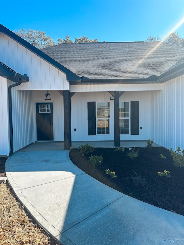 property entrance featuring roof with shingles