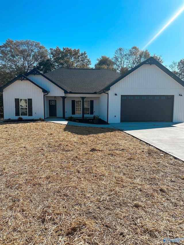 view of front of house with a garage, concrete driveway, and a front yard