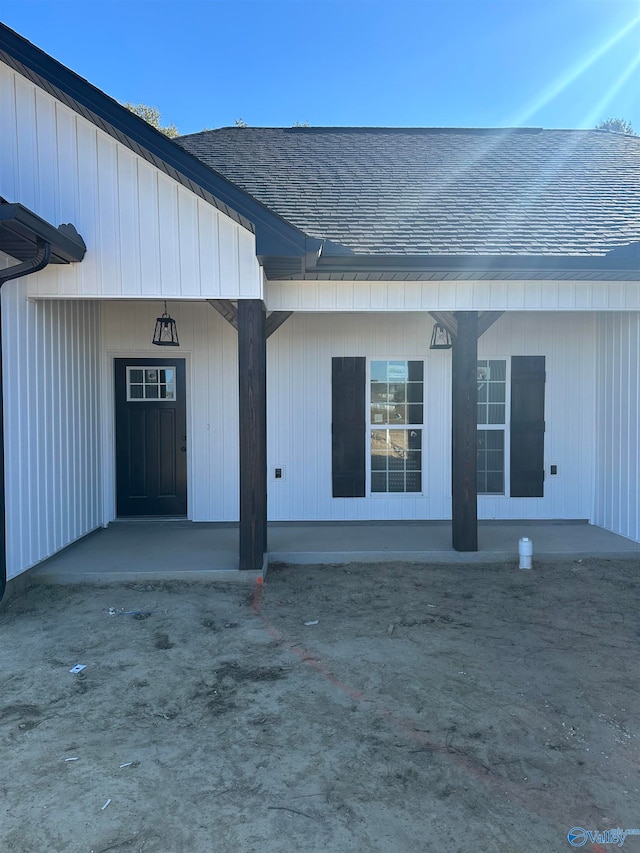 property entrance featuring roof with shingles