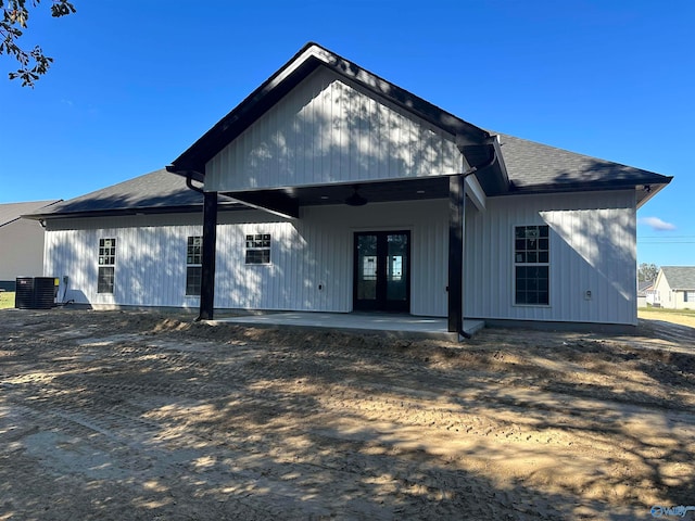 rear view of property with a shingled roof, french doors, a patio, and central air condition unit