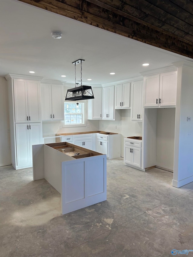 kitchen with white cabinets, a kitchen island, and decorative light fixtures