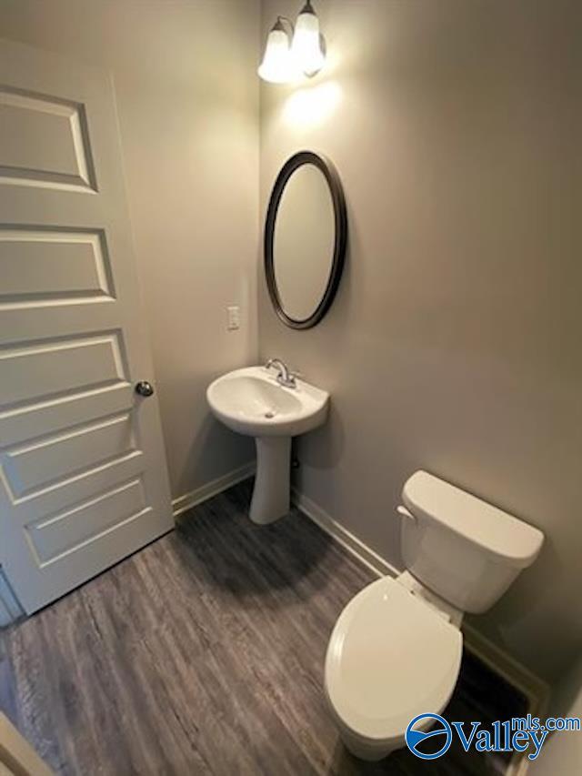 bathroom with hardwood / wood-style flooring, toilet, and sink