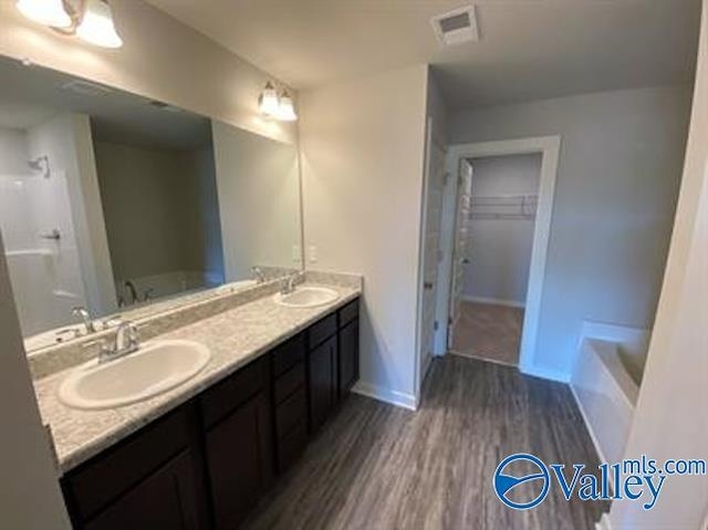 bathroom featuring hardwood / wood-style flooring, vanity, and a bathtub