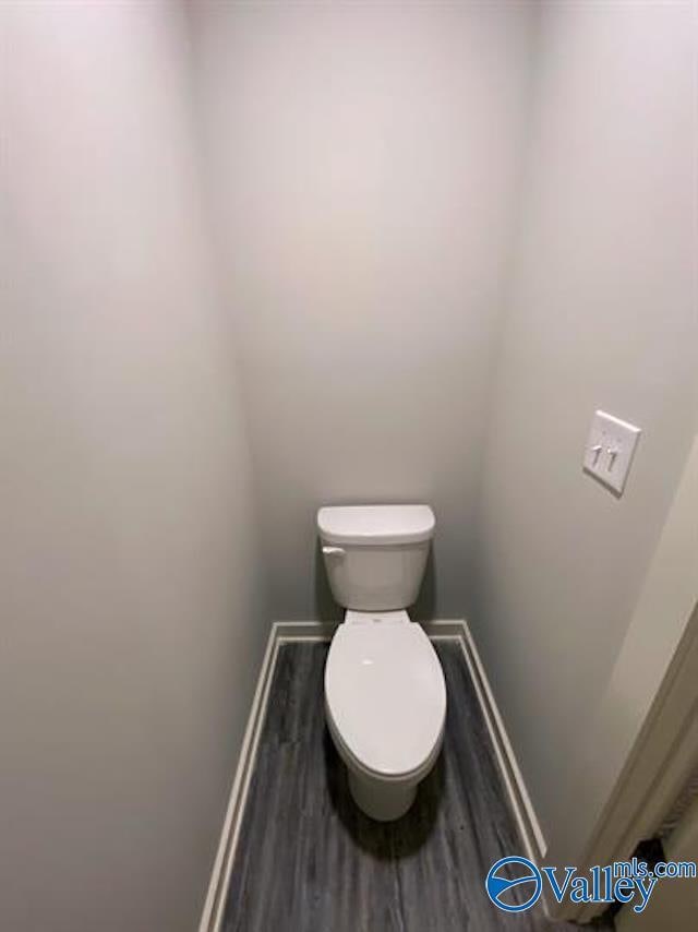 bathroom with hardwood / wood-style flooring and toilet