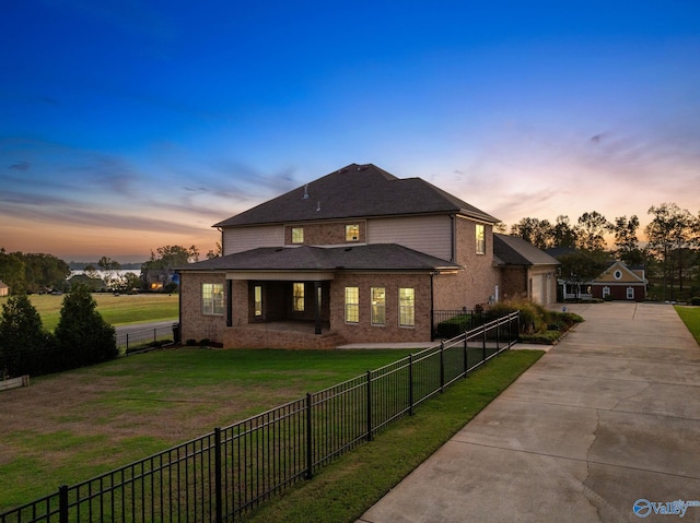 exterior space with brick siding, fence private yard, a lawn, and driveway