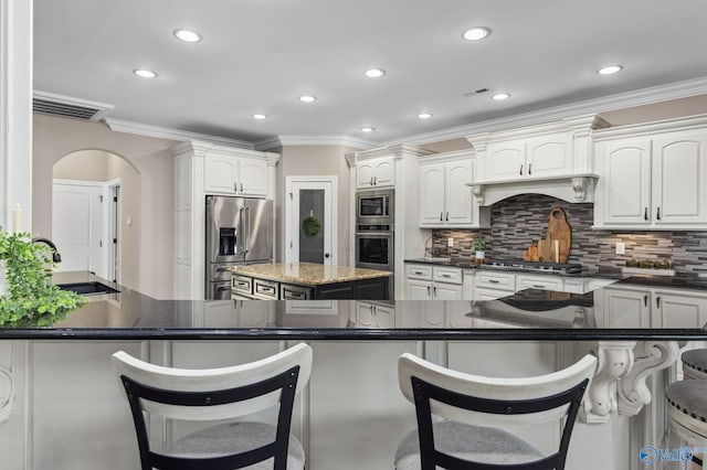 kitchen featuring crown molding, arched walkways, visible vents, appliances with stainless steel finishes, and a sink